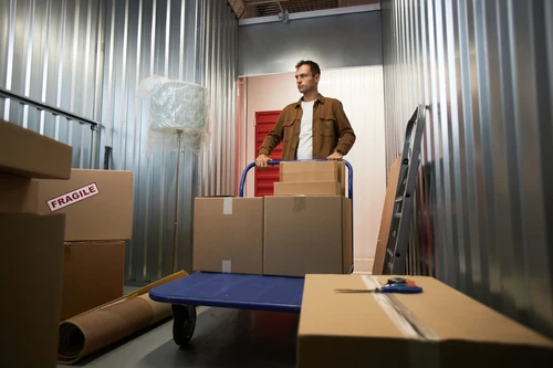 Aerial view of furniture and boxes neatly organized in rows on a wood floor, illustrating storage unit space planning.